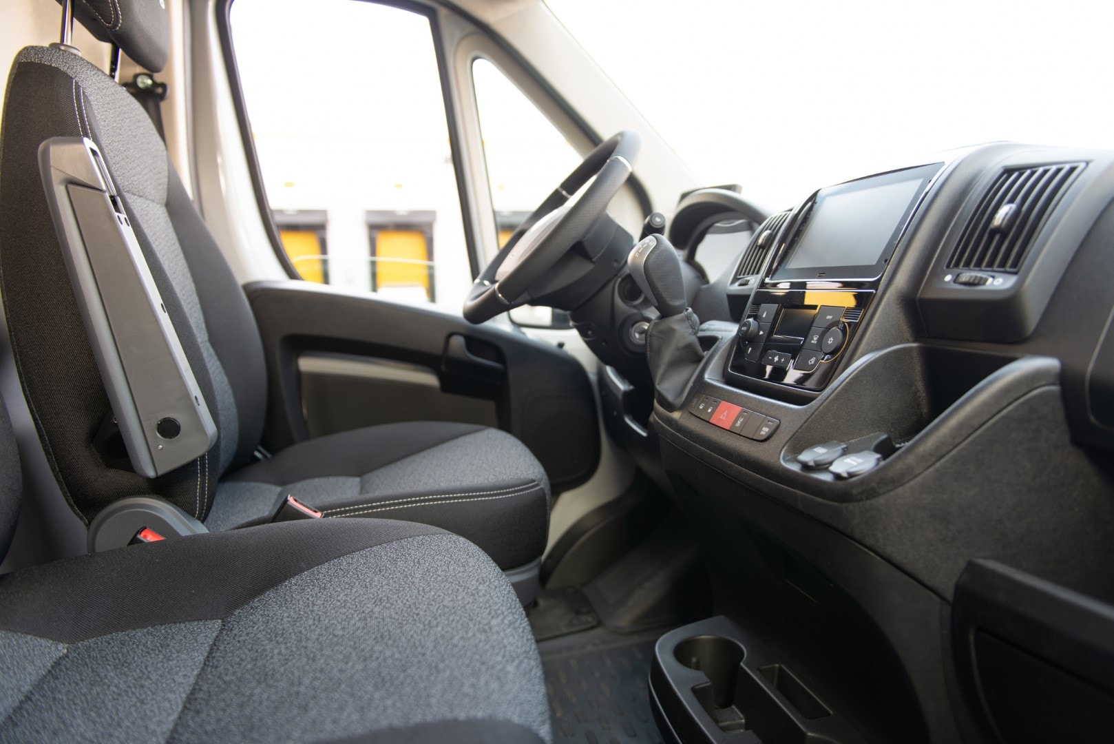 Vista interior de la cabina del Fiat Ducato eléctrico, destacando el confort y espacio de los asientos.