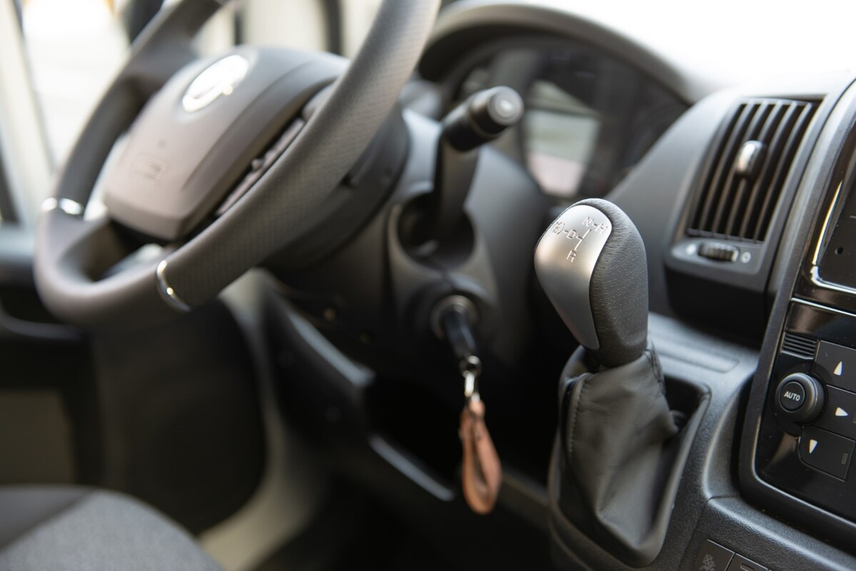 Enfoque en el puesto de conducción mostrando volante y palanca de cambios. Enfoque en el puesto de conducción mostrando volante y palanca de cambios.