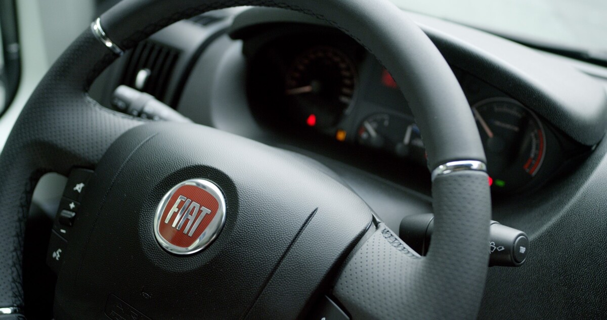 Vista del volante y los instrumentos de un Fiat Ducato eléctrico, enfocando en el emblema. Vista del volante y los instrumentos de un Fiat Ducato eléctrico, enfocando en el emblema.