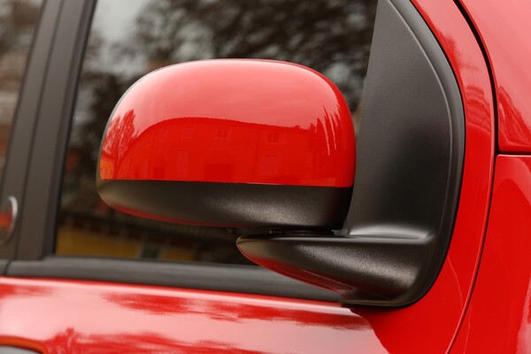 Primer plano del espejo lateral del Fiat Panda, enfatizando los detalles y acabados en color rojo. Primer plano del espejo lateral del Fiat Panda, enfatizando los detalles y acabados en color rojo.
