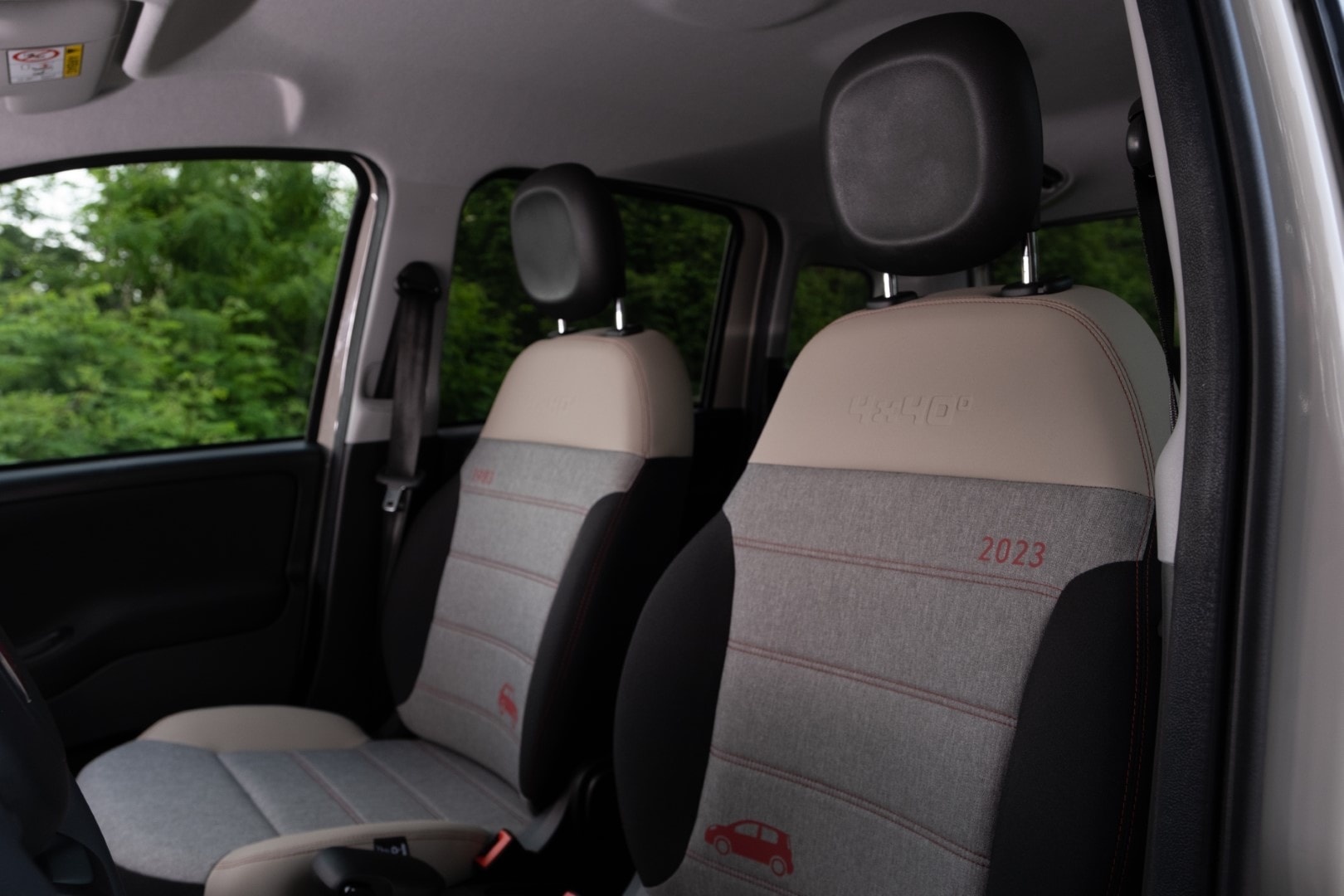 Asientos con tapicería textil y logo 2023, confortables y funcionales.