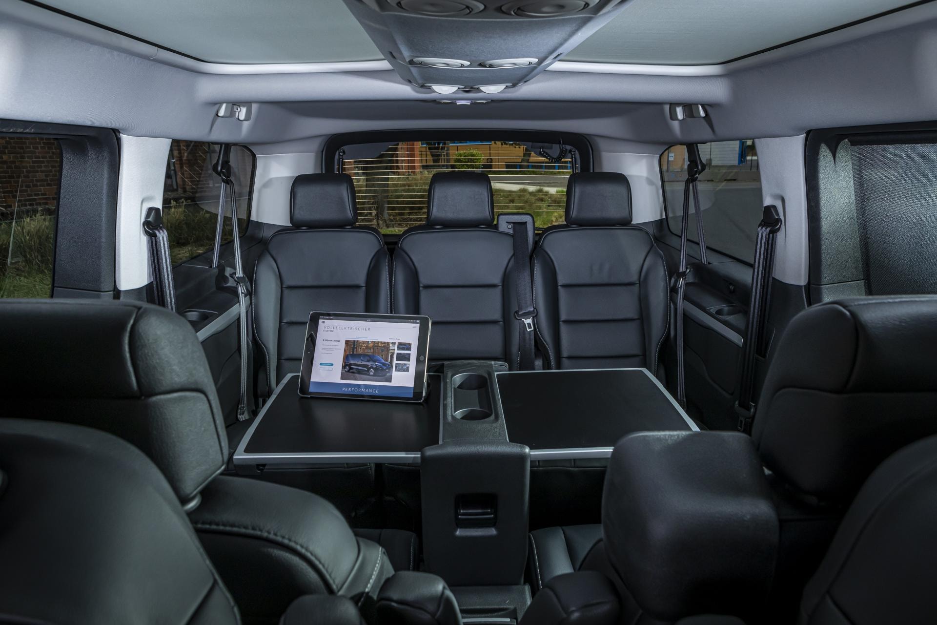 Configuración ejecutiva del interior con mesas plegables y asientos de cuero.