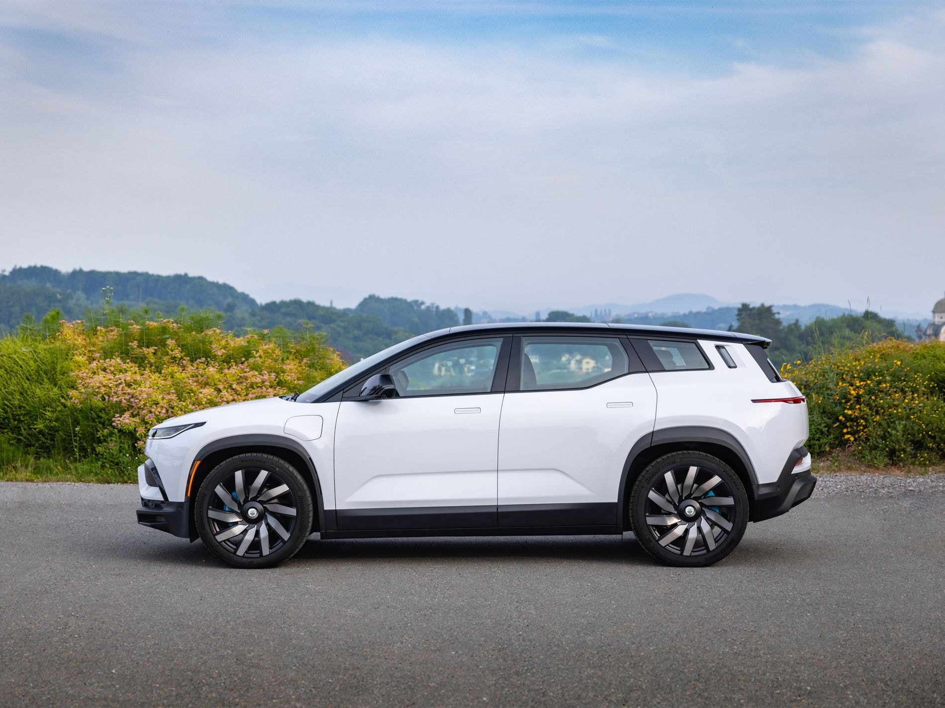 Vista lateral completa del Fisker Ocean en un entorno campestre.