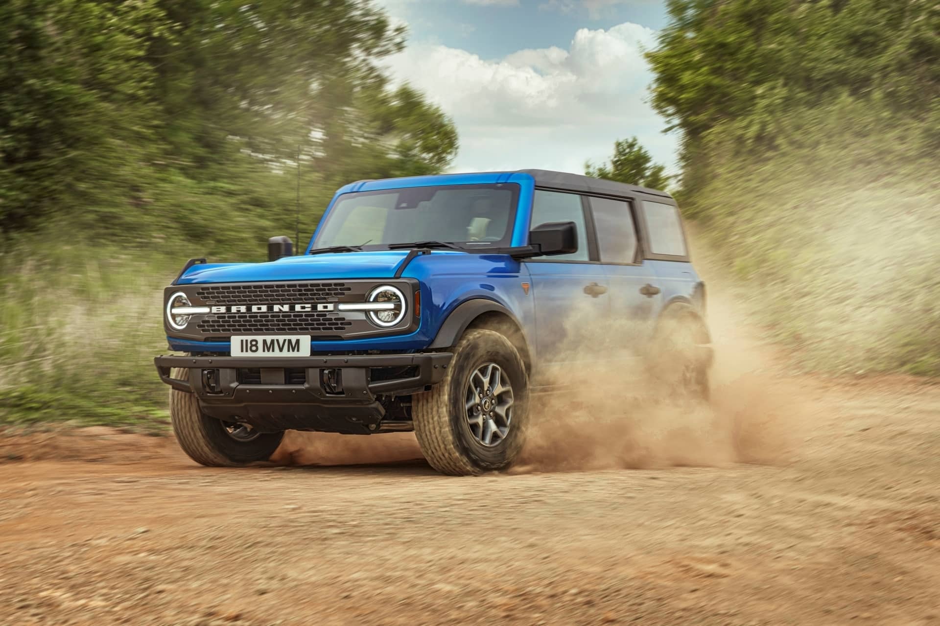 Imagen dinámica del Bronco en plena acción, levantando polvo en un camino rural.
