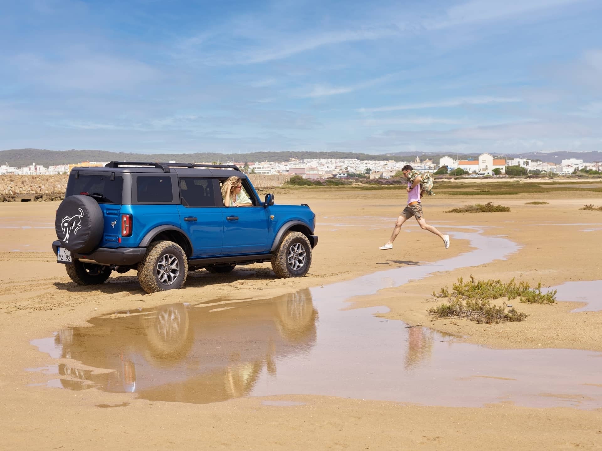 Ford Bronco reflectado en un charco, mostrando su lateral.