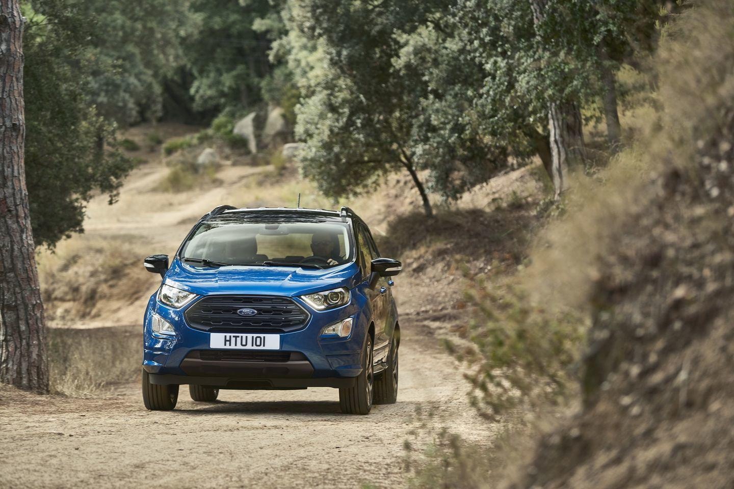 Ford Ecosport azul avanzando en terreno forestal, vista frontal