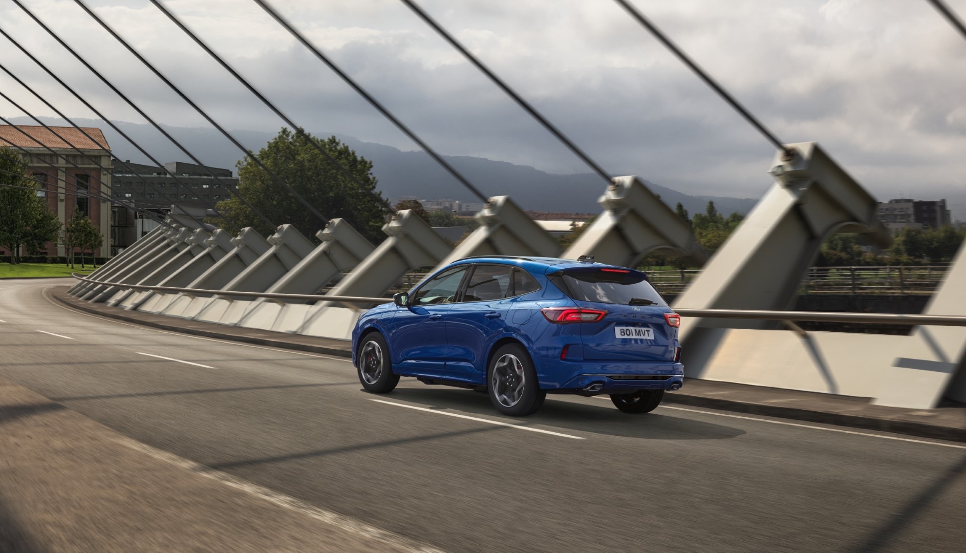 Ford Kuga en color azul contrastando con la arquitectura moderna