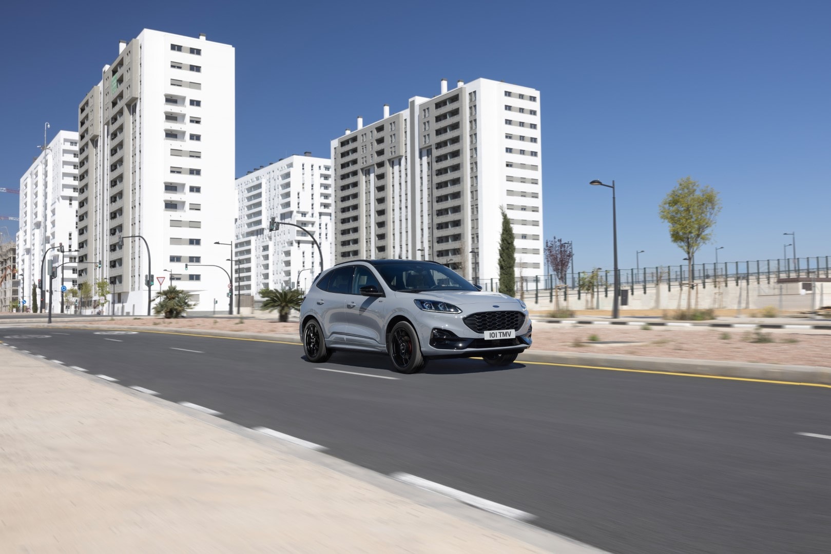 Ford Kuga blanco en un paisaje urbano moderno, mostrando su perfil