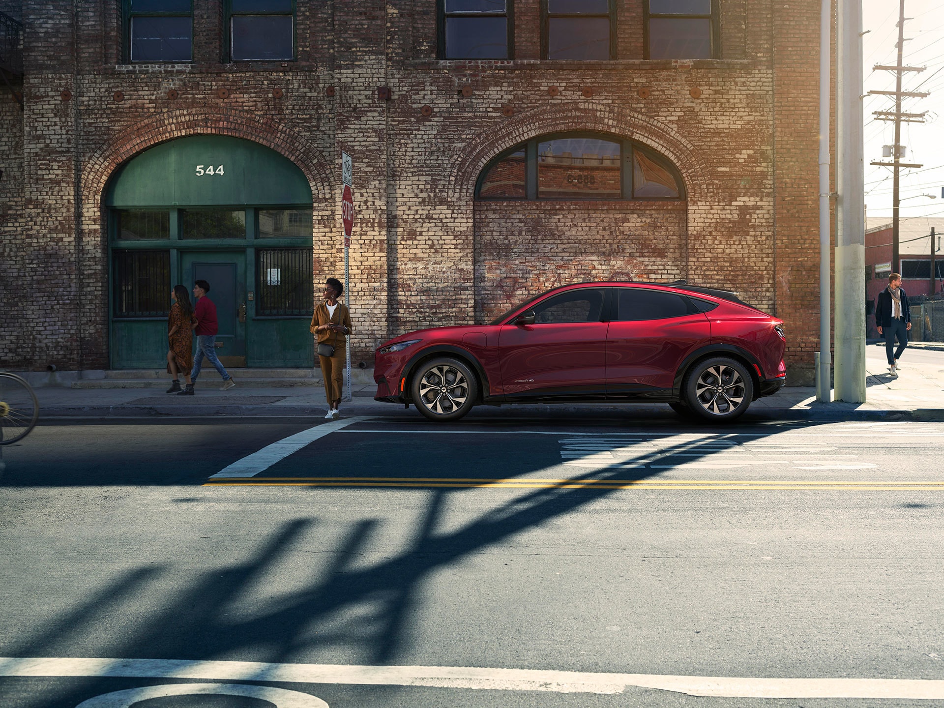 Ford Mustang Mach-E rojo en entorno urbano, demostrando su estilo moderno.