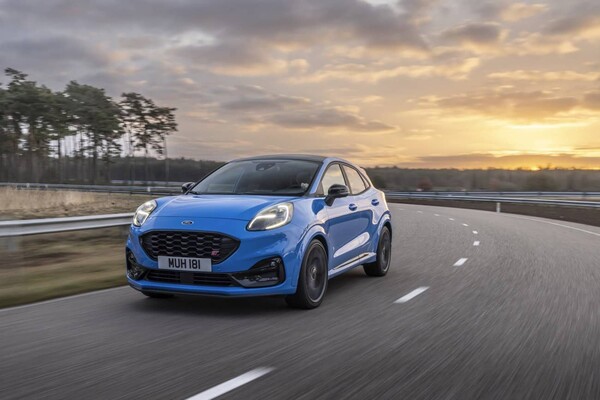 Vista lateral delantera del Ford Puma ST en carretera al atardecer.