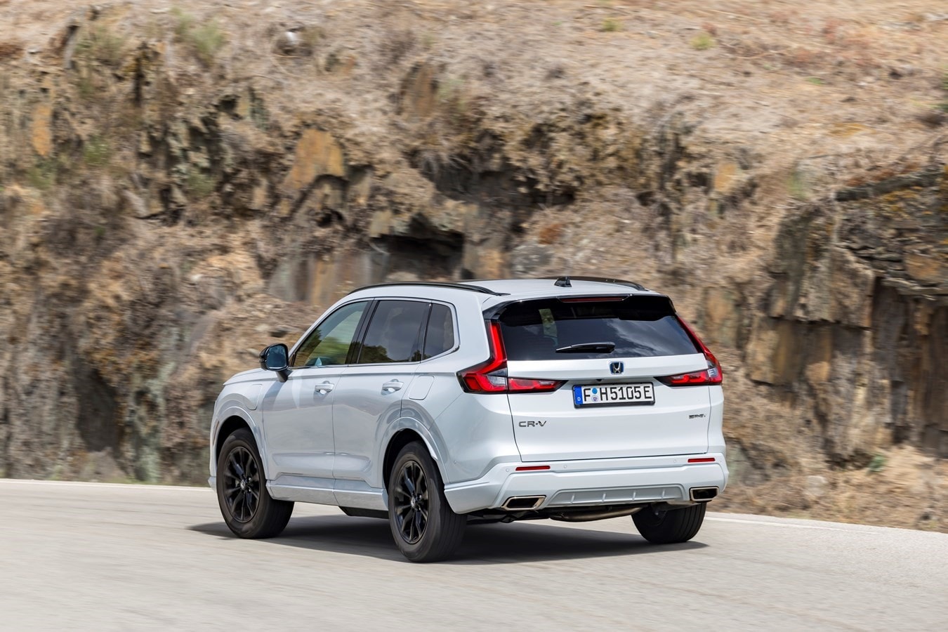 Vista trasera del Honda CR-V híbrido en curva, mostrando su diseño aerodinámico.
