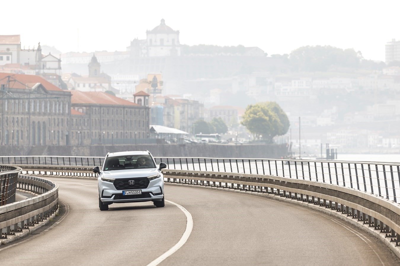 Vista lateral del Honda CR-V híbrido cruzando un puente, ilustrando su versatilidad.