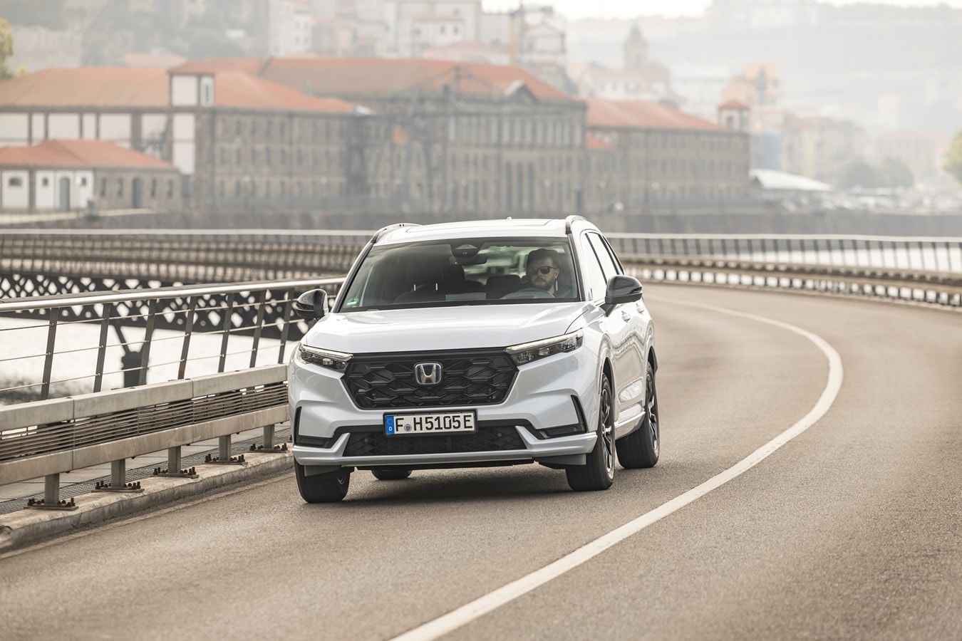 Perspectiva lateral del Honda CR-V híbrido junto a la costa, obteniendo un aire fresco.