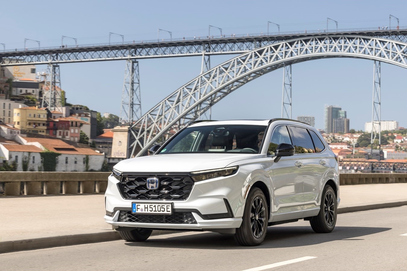 El elegante diseño frontal del Honda CR-V híbrido resalta ante un impresionante puente.