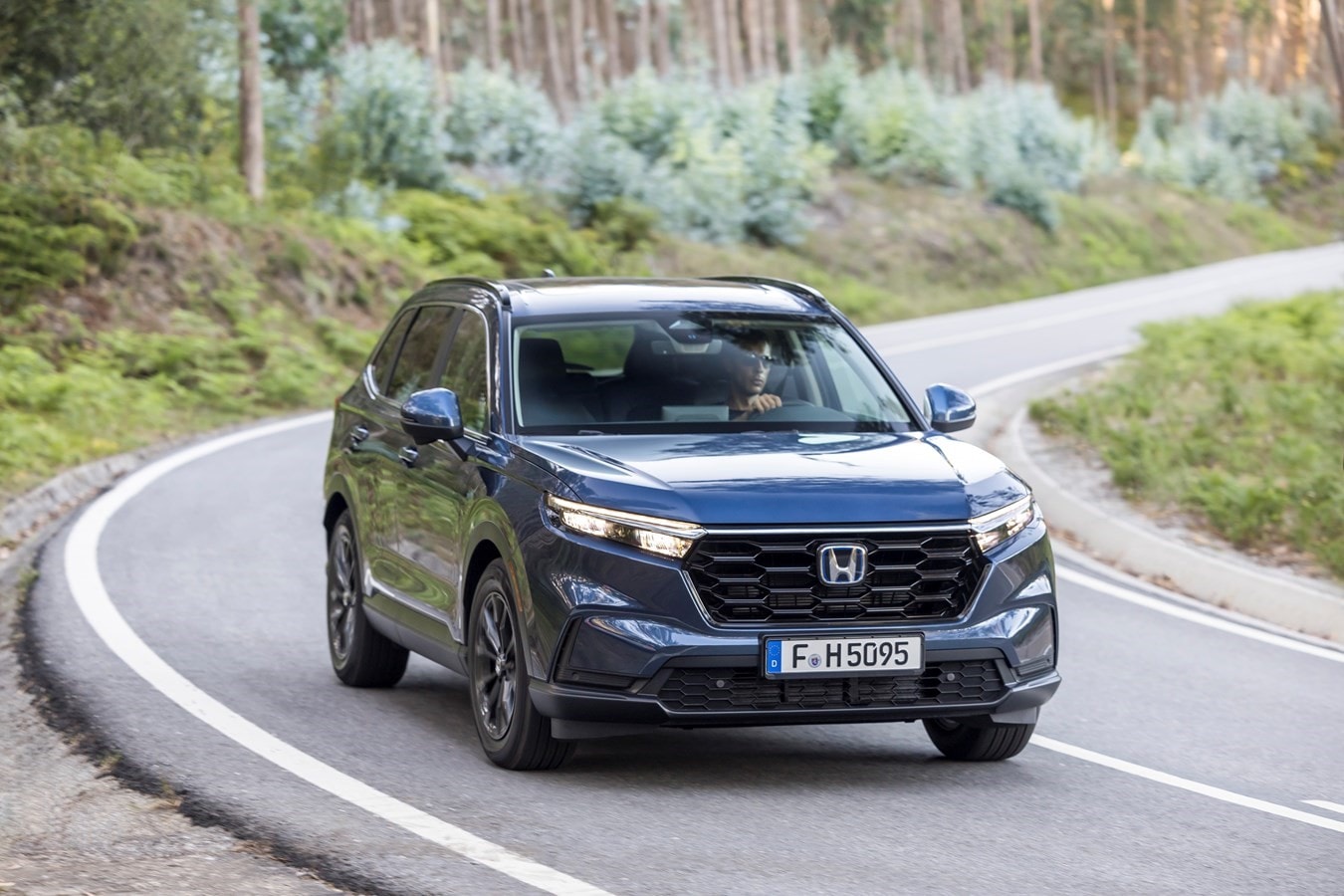 Honda CR-V híbrido en movimiento sobre un puente, reflejando su agilidad y confort en ruta.