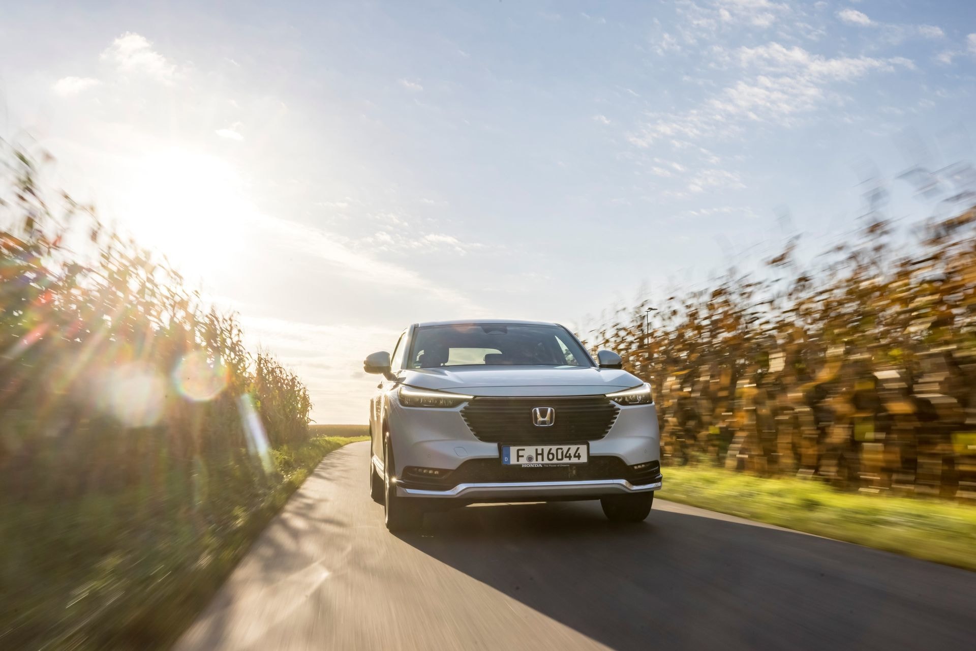 Honda HR-V híbrido en ruta con iluminación natural de fondo.