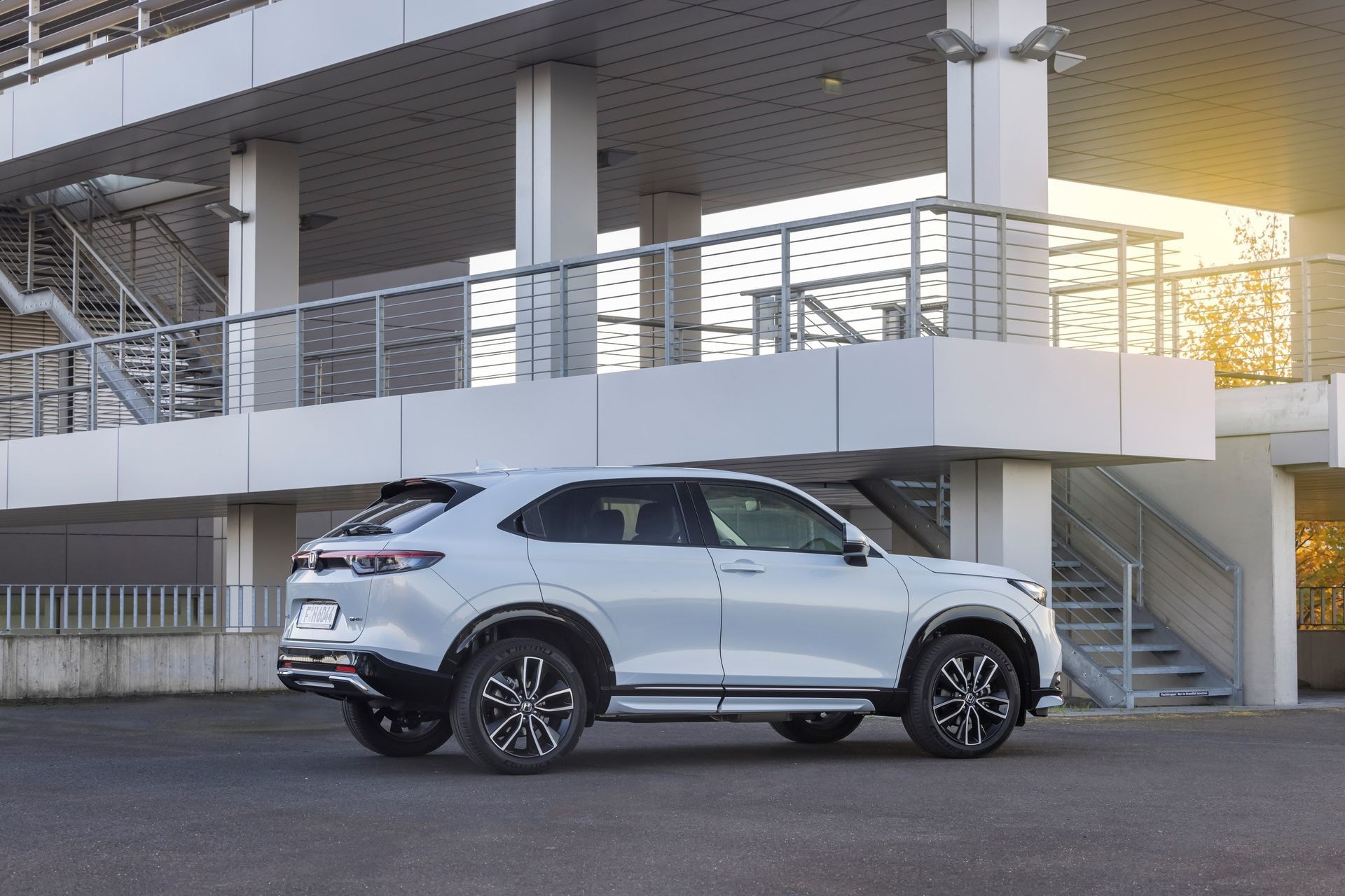 Honda HR-V híbrido estacionado, vista lateral con edificio de fondo.