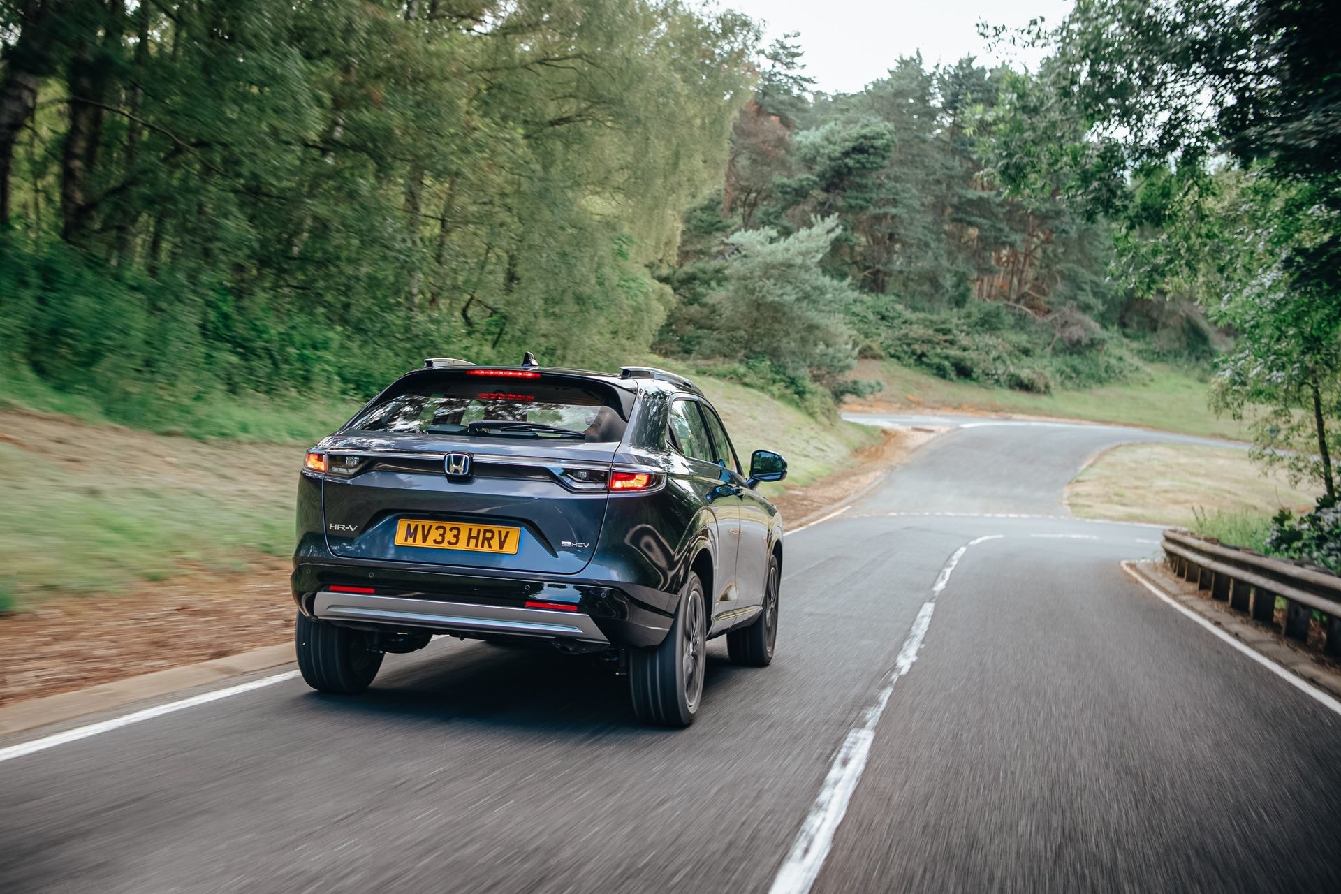 Imagen dinámica de la trasera del Honda HR-V híbrido en carretera.