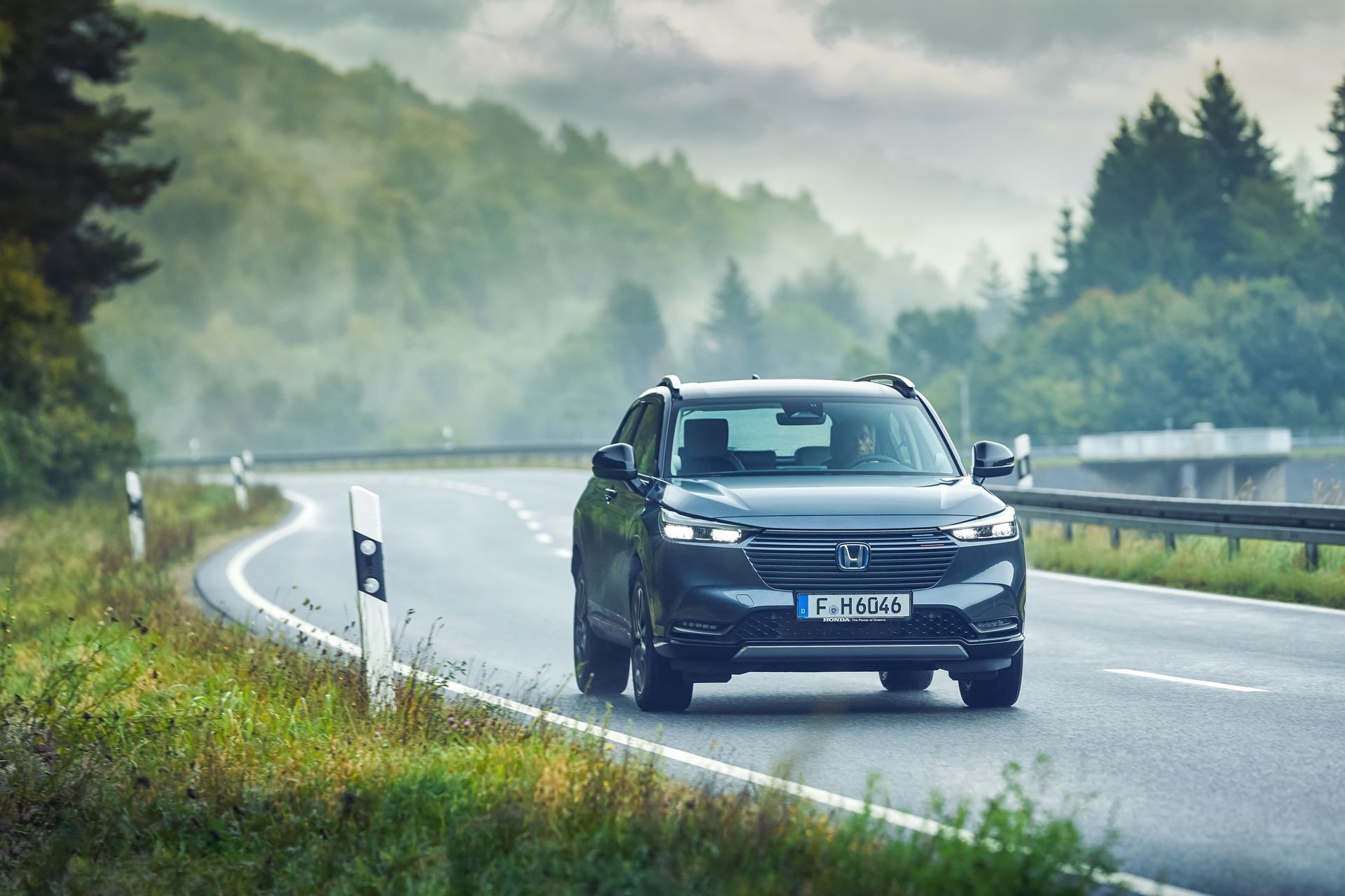 Honda HR-V híbrido circulando en carretera, destacando su diseño aerodinámico.