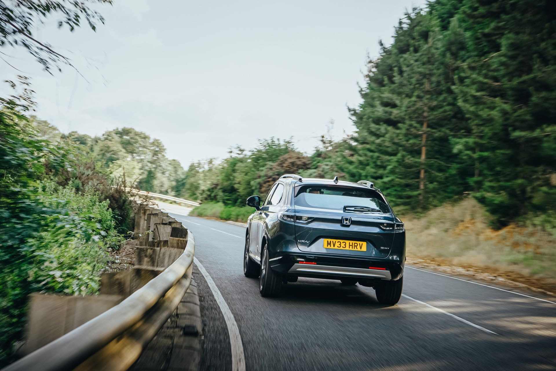Imagen en acción de la parte trasera del Honda HR-V híbrido, en ruta curvada.