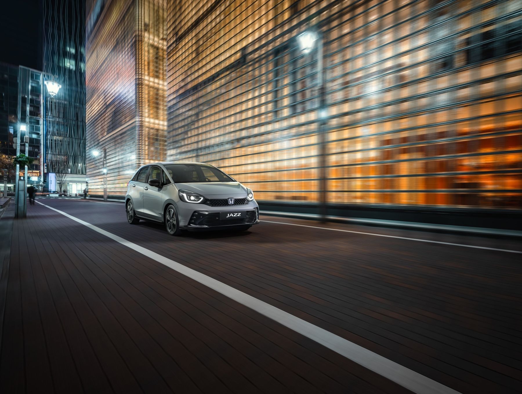 Honda Jazz en movimiento por la ciudad, destacando su elegancia nocturna.