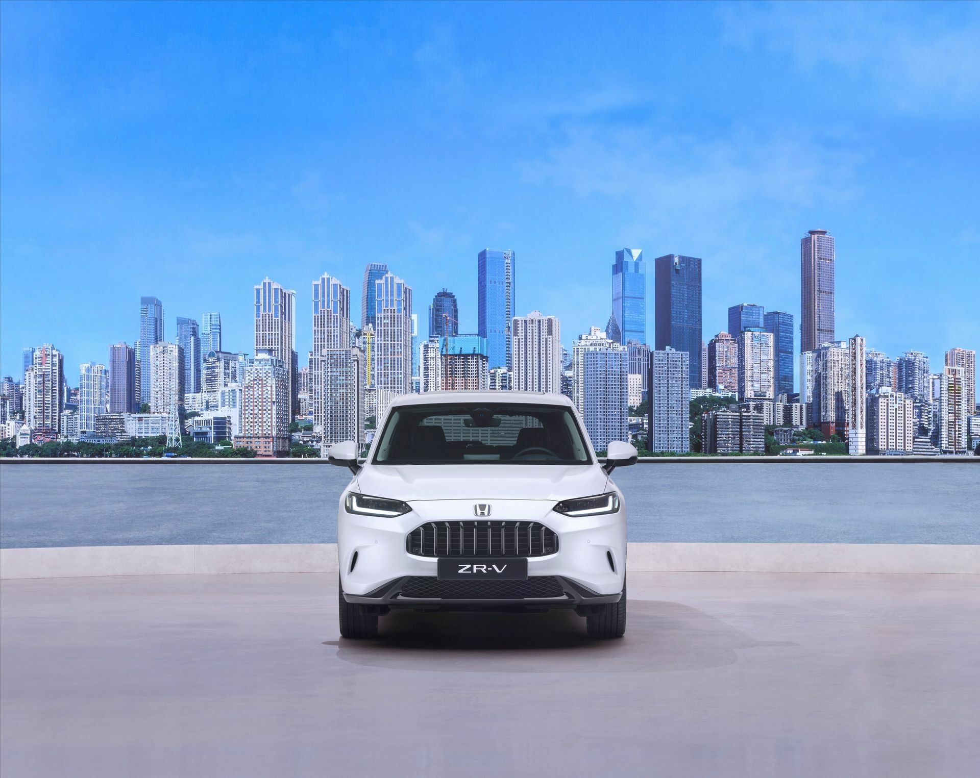 Frente del Honda ZR-V capturado con un fondo urbano, resalta su parrilla y faros.