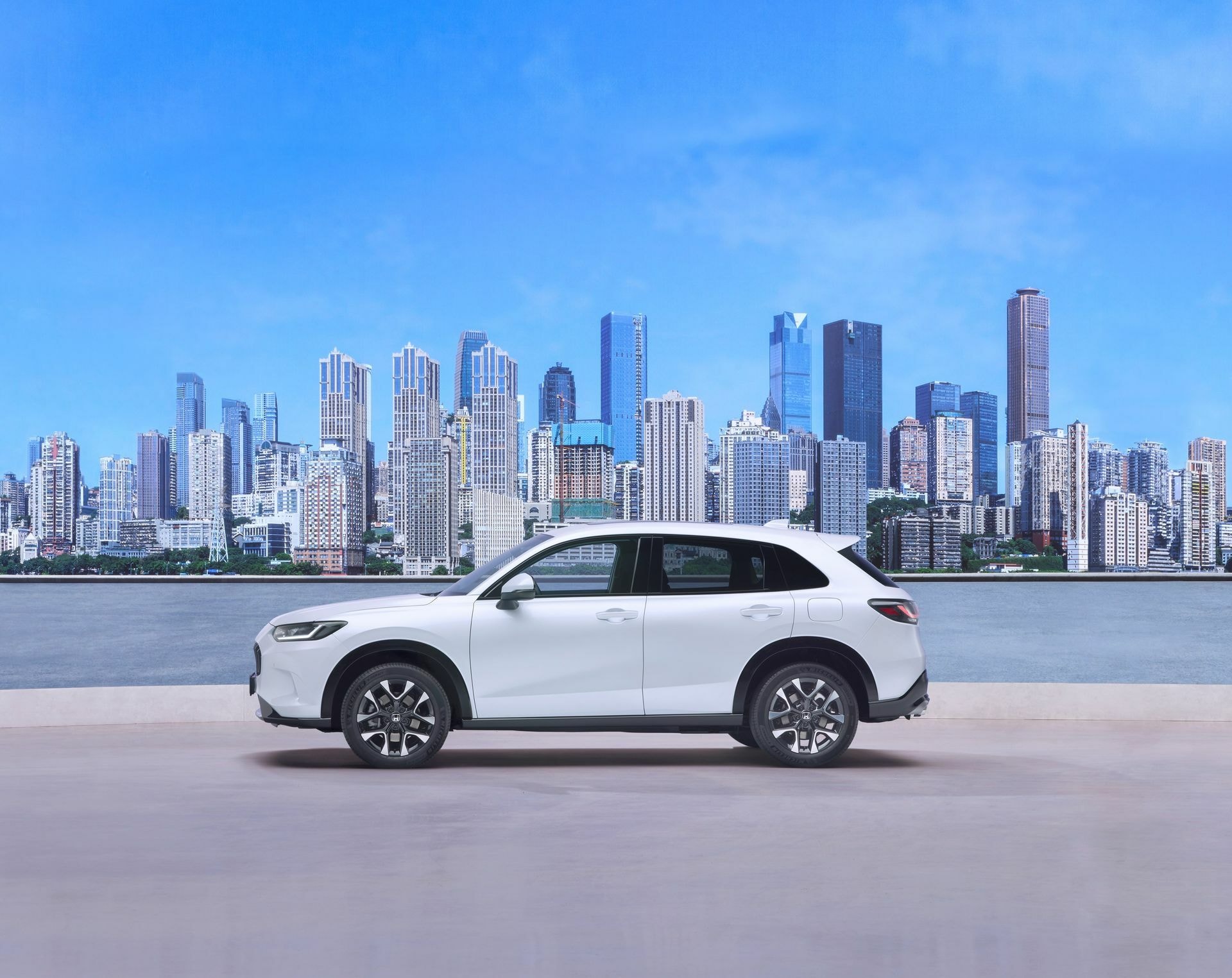 Vista lateral del Honda ZR-V sobre fondo urbano, destacando su diseño moderno.