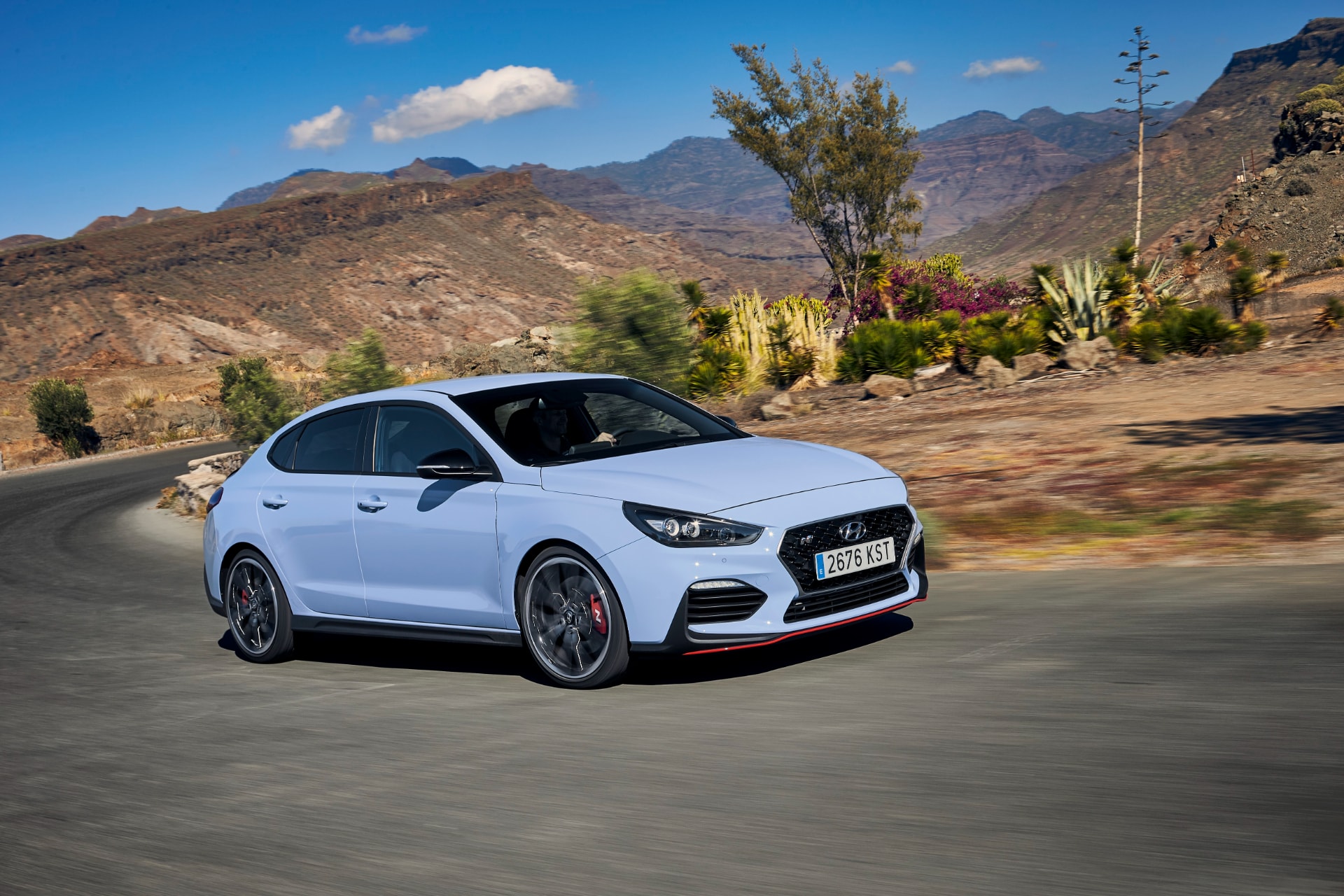 Vista lateral en movimiento del Hyundai i30 N Fastback, destacando su línea deportiva.
