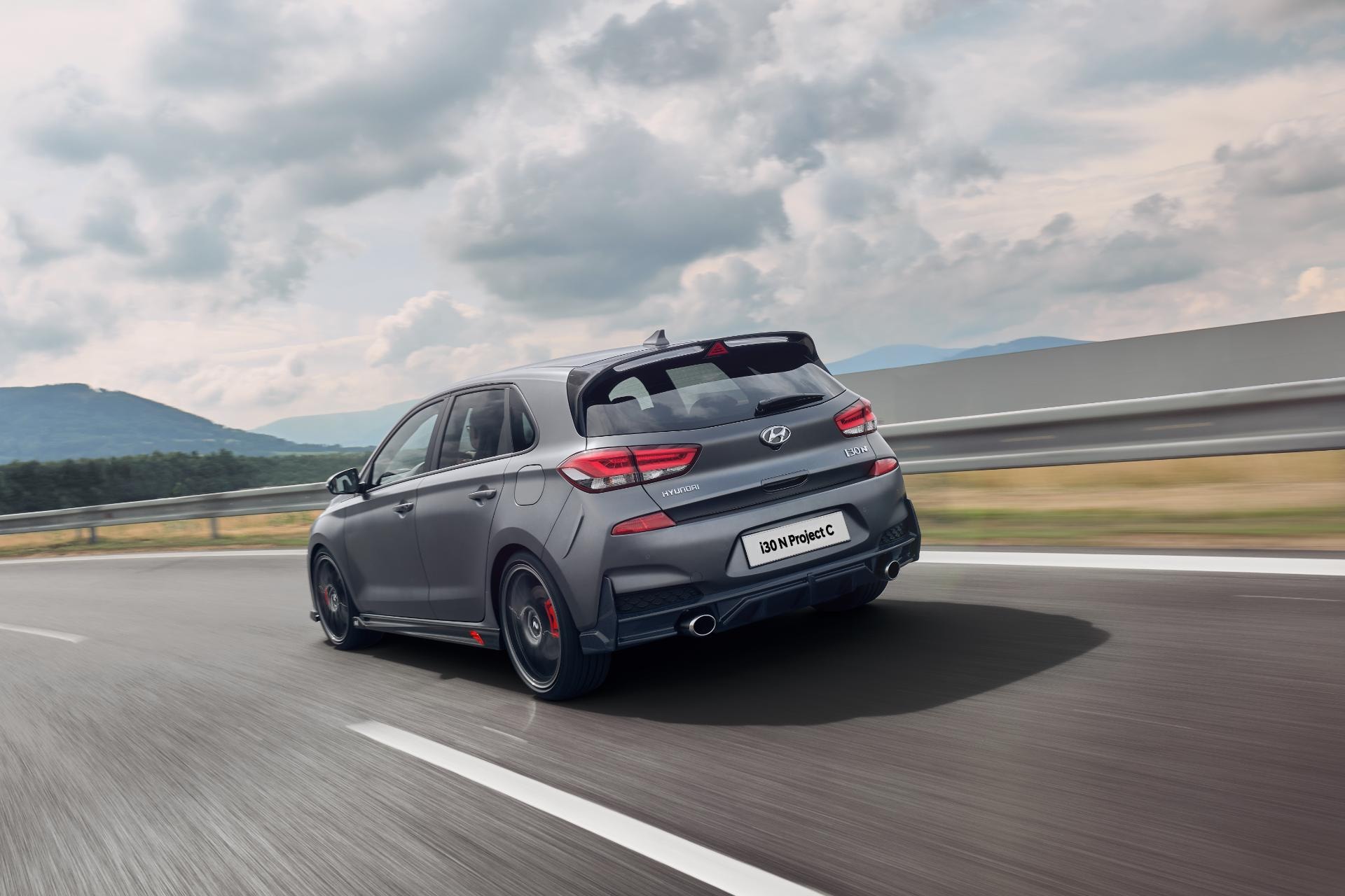Toma trasera lateral del Hyundai i30 N en velocidad, destacando su aerodinámica y línea de escapes.