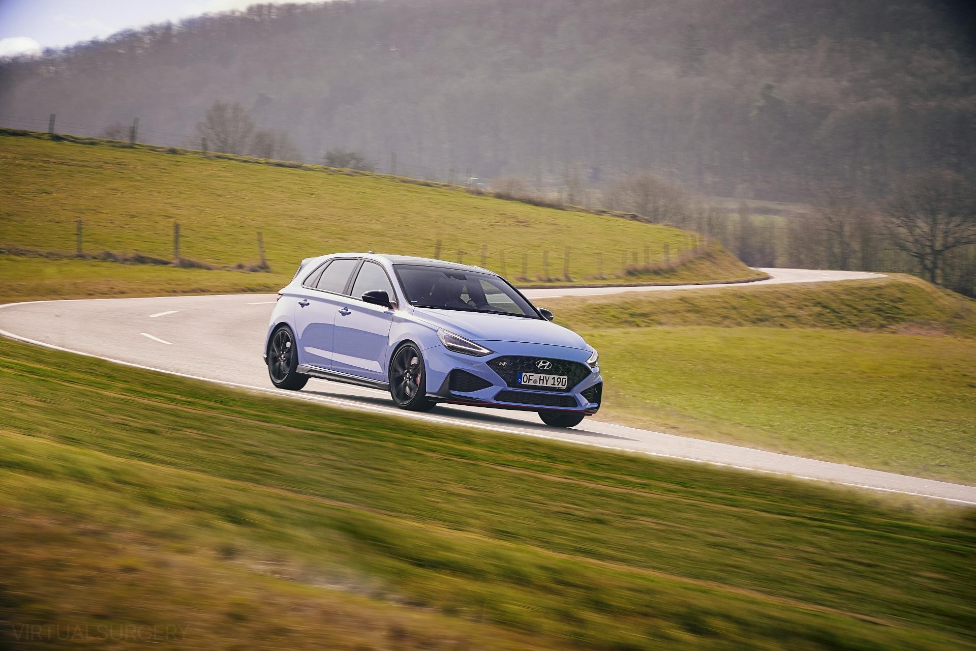 Vista lateral del i30 N en carretera, enfatiza su perfil deportivo.