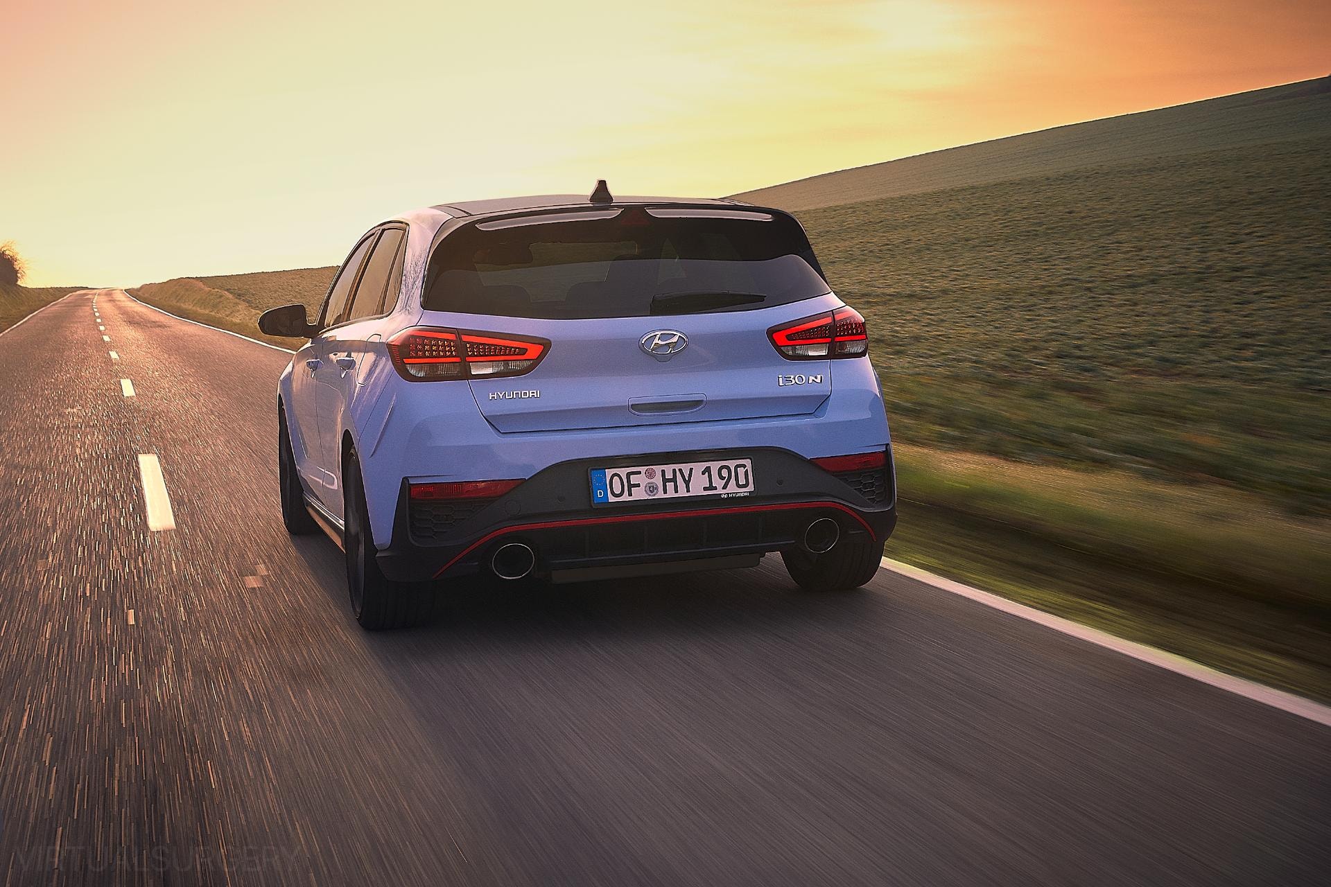 Perfil trasero del i30 N durante una puesta de sol, subrayando su estética deportiva.