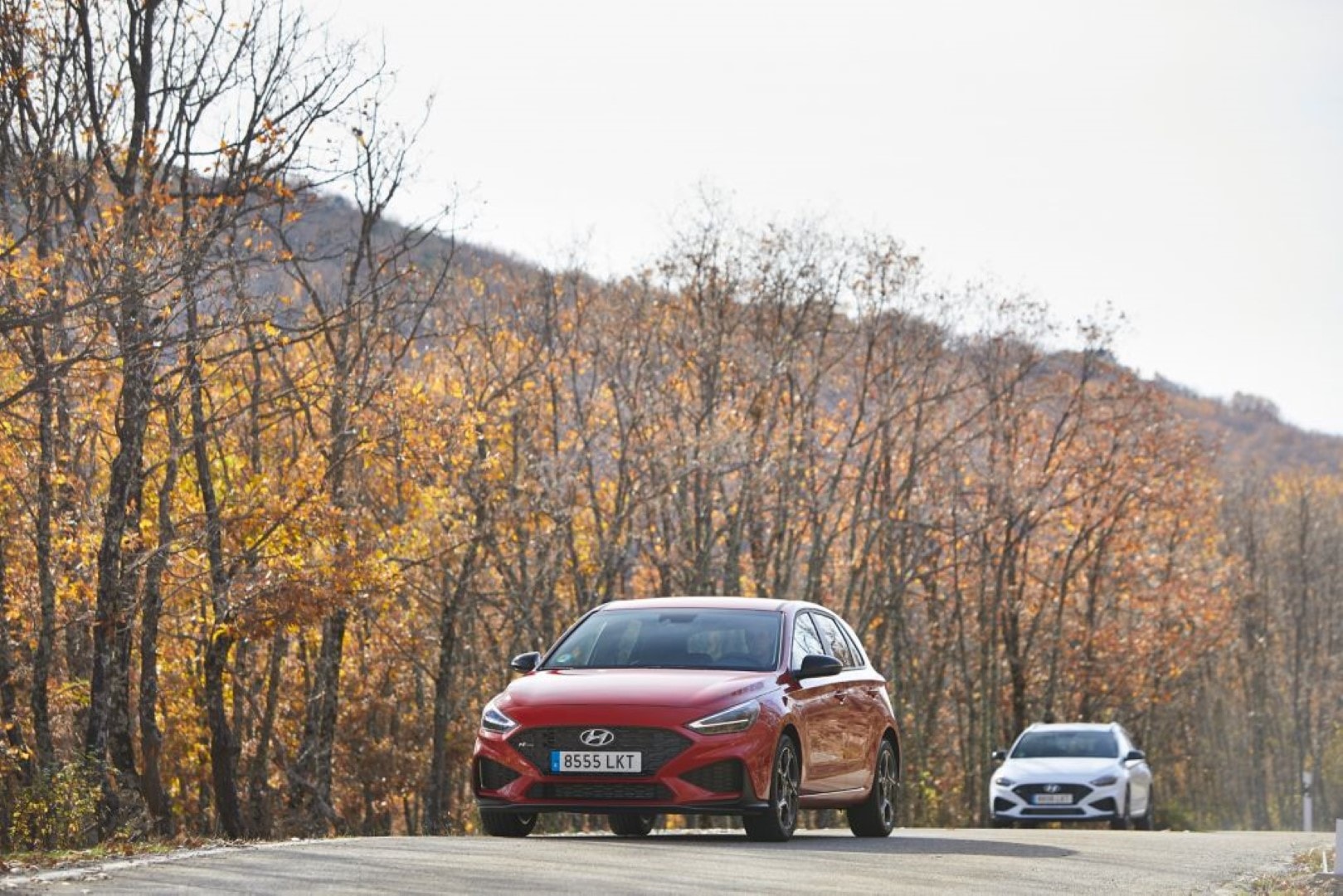 Hyundai i30 en movimiento mostrando su perfil y llantas mientras rodea una curva.