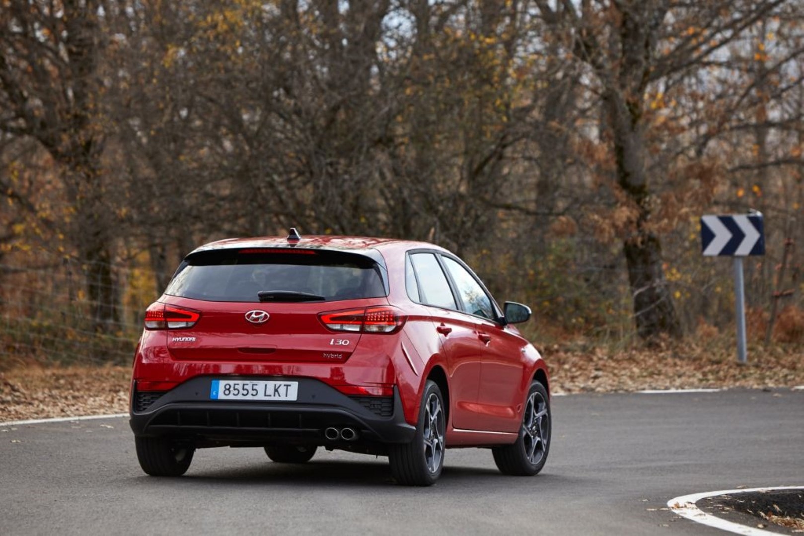 Hyundai i30 capturado desde atrás tomando una curva, mostrando su diseño de faros traseros.