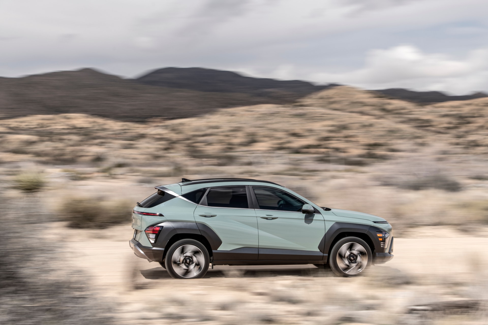 Vista dinámica del Hyundai Kona Híbrido en movimiento por terreno desértico.