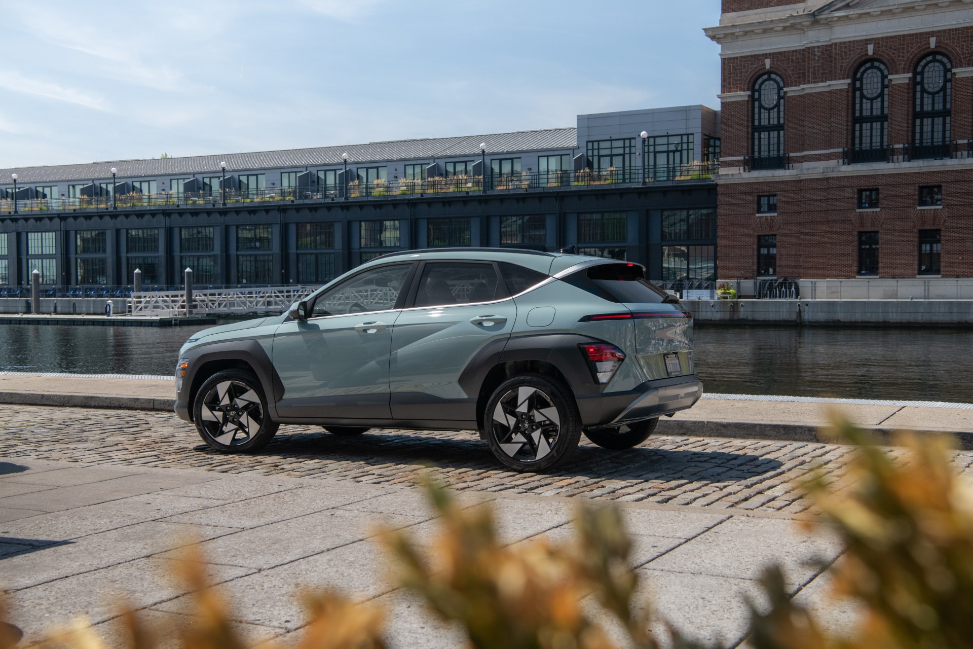 Vista en tres cuartos trasera del Hyundai Kona Híbrido integrándose en el entorno urbano