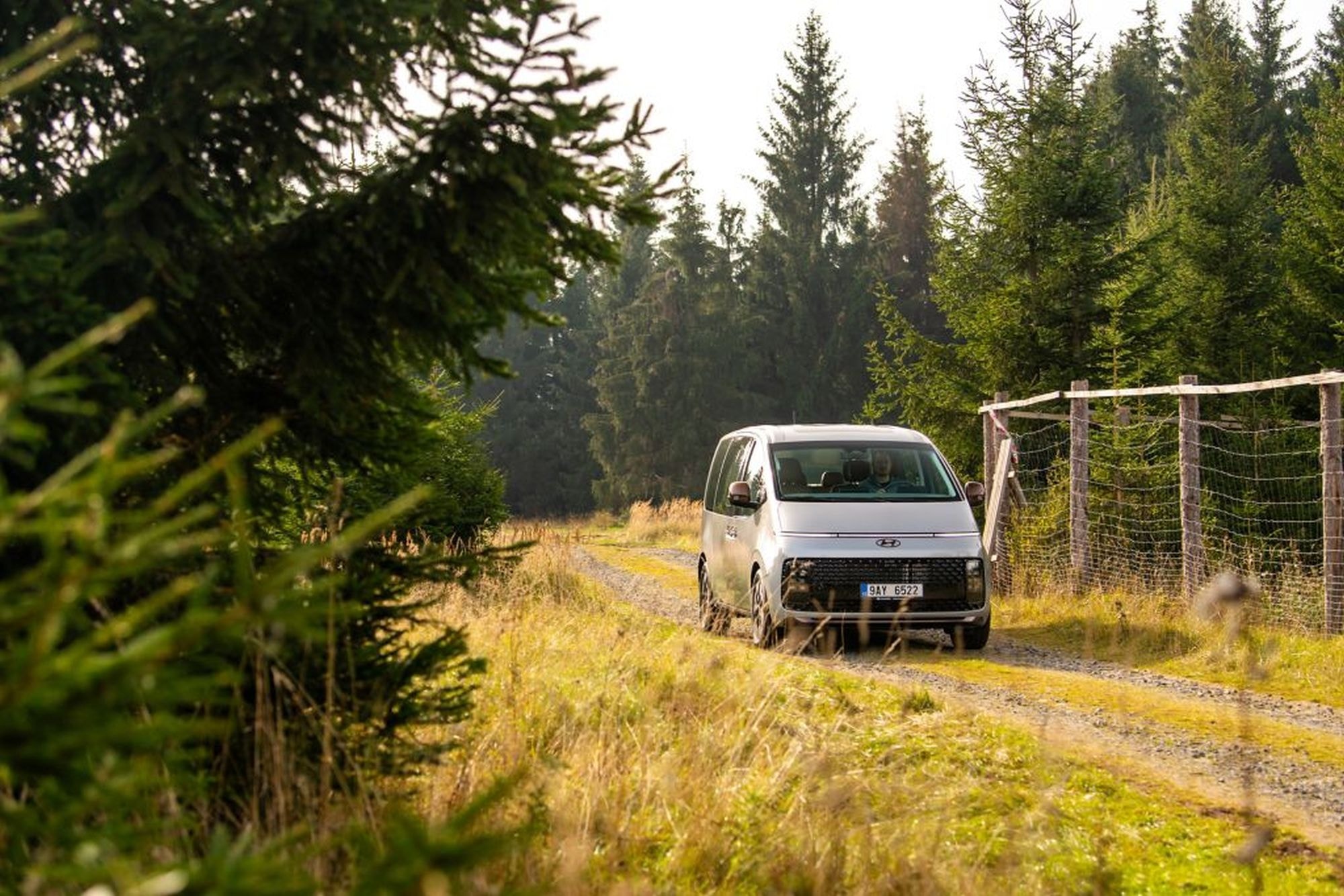 Vista lateral del Hyundai Staria híbrido en un entorno natural.