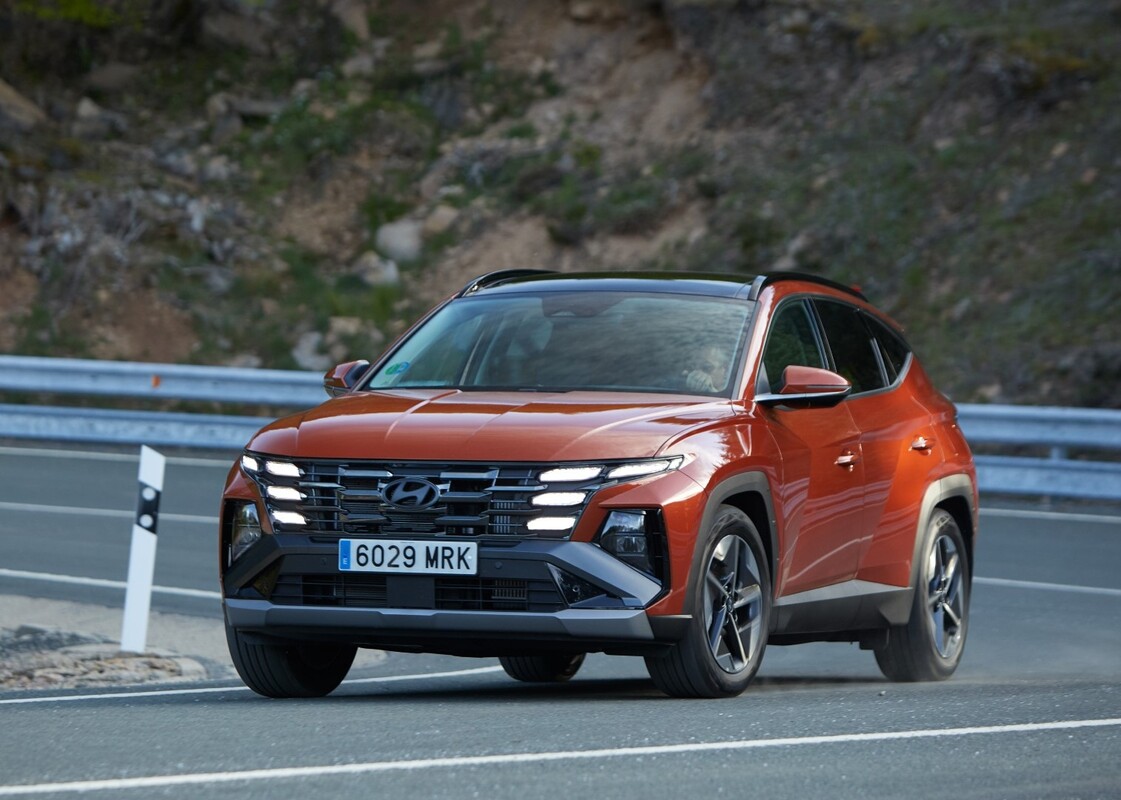 Hyundai Tucson rojo en movimiento, mostrando su diseño frontal dinámico. Hyundai Tucson rojo en movimiento, mostrando su diseño frontal dinámico.