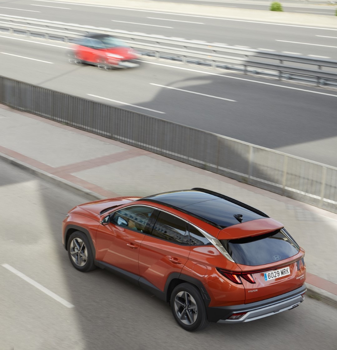 Vista en ángulo elevado de la parte trasera y el techo del Tucson en ambiente urbano.