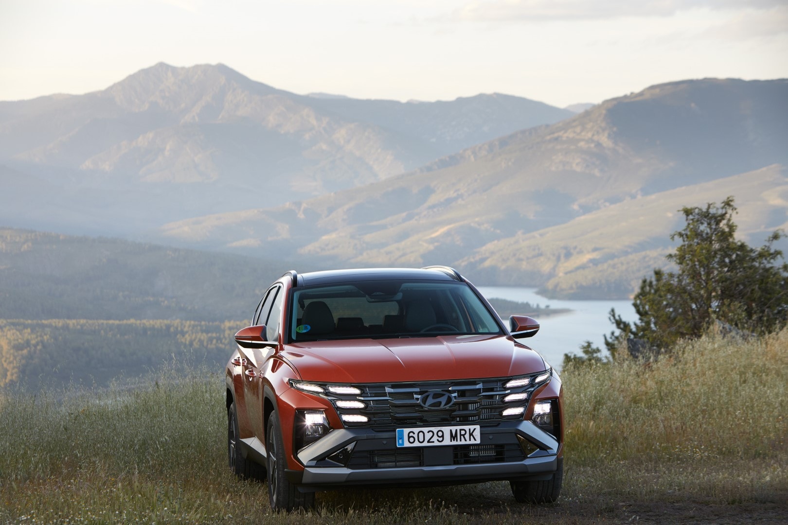 Imagen frontal del Hyundai Tucson contrastando con el entorno natural, robustez en su diseño.