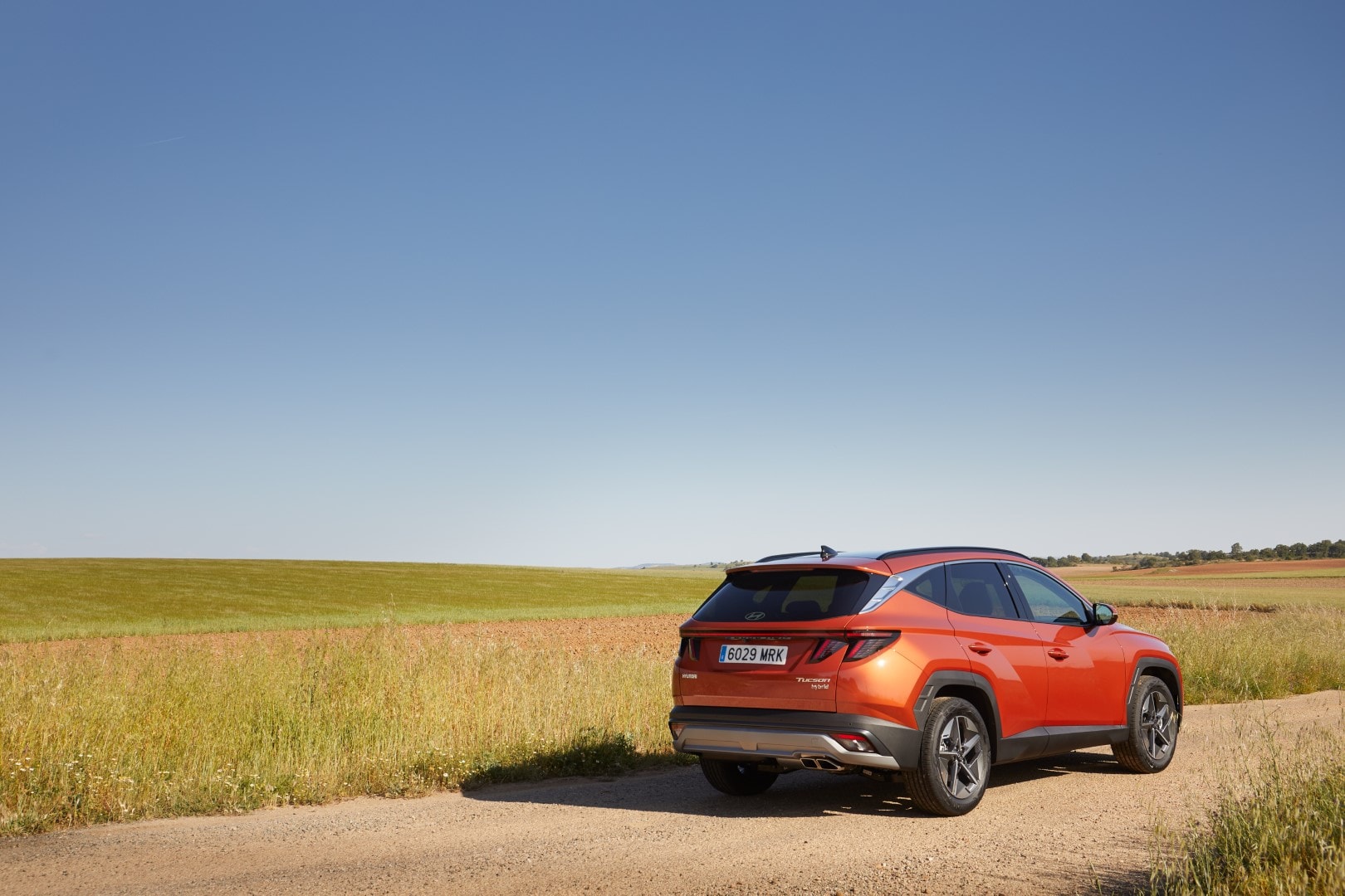 Tucson de perfil en paisaje abierto, resaltando su proporción y diseño lateral.