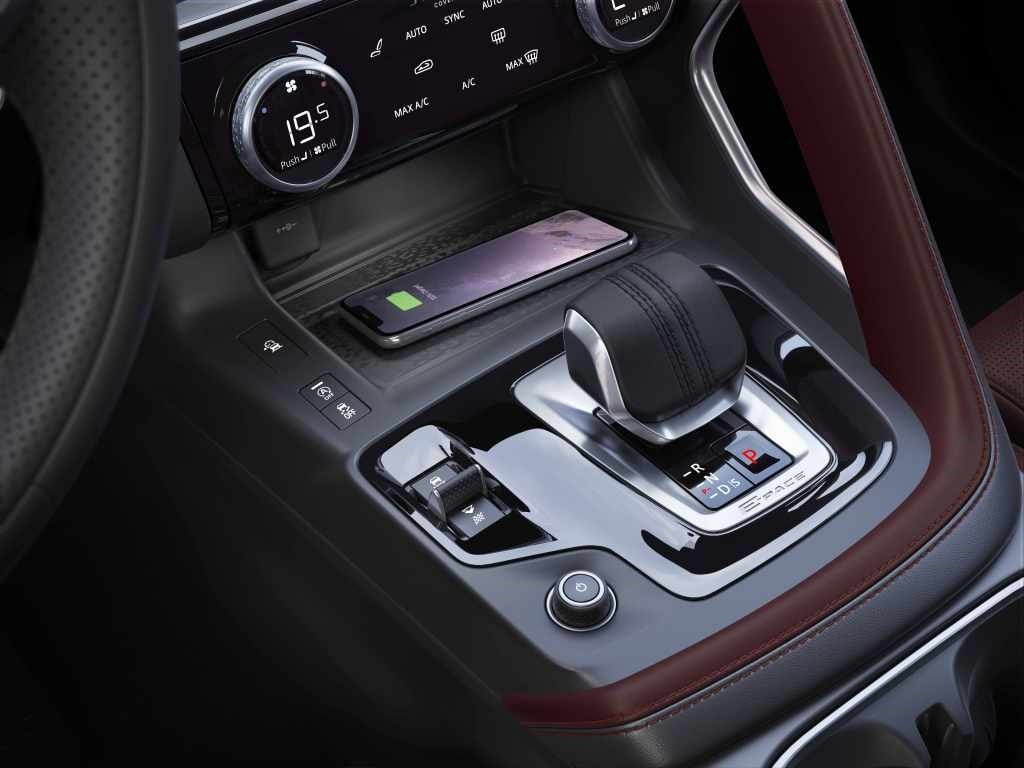 Consola central del Jaguar E-Pace Híbrido con detalles de carga inalámbrica para móviles.