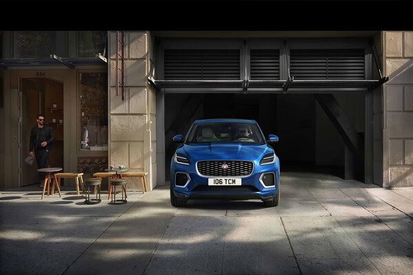 Un Jaguar E-Pace azul haciendo su aparición desde un moderno garaje urbano. Un Jaguar E-Pace azul haciendo su aparición desde un moderno garaje urbano.
