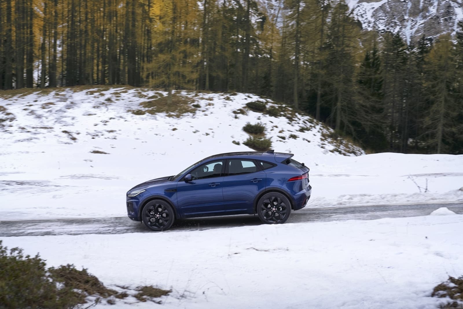 Jaguar E-Pace en acción lateral sobre la nieve reflejando su capacidad dinámica