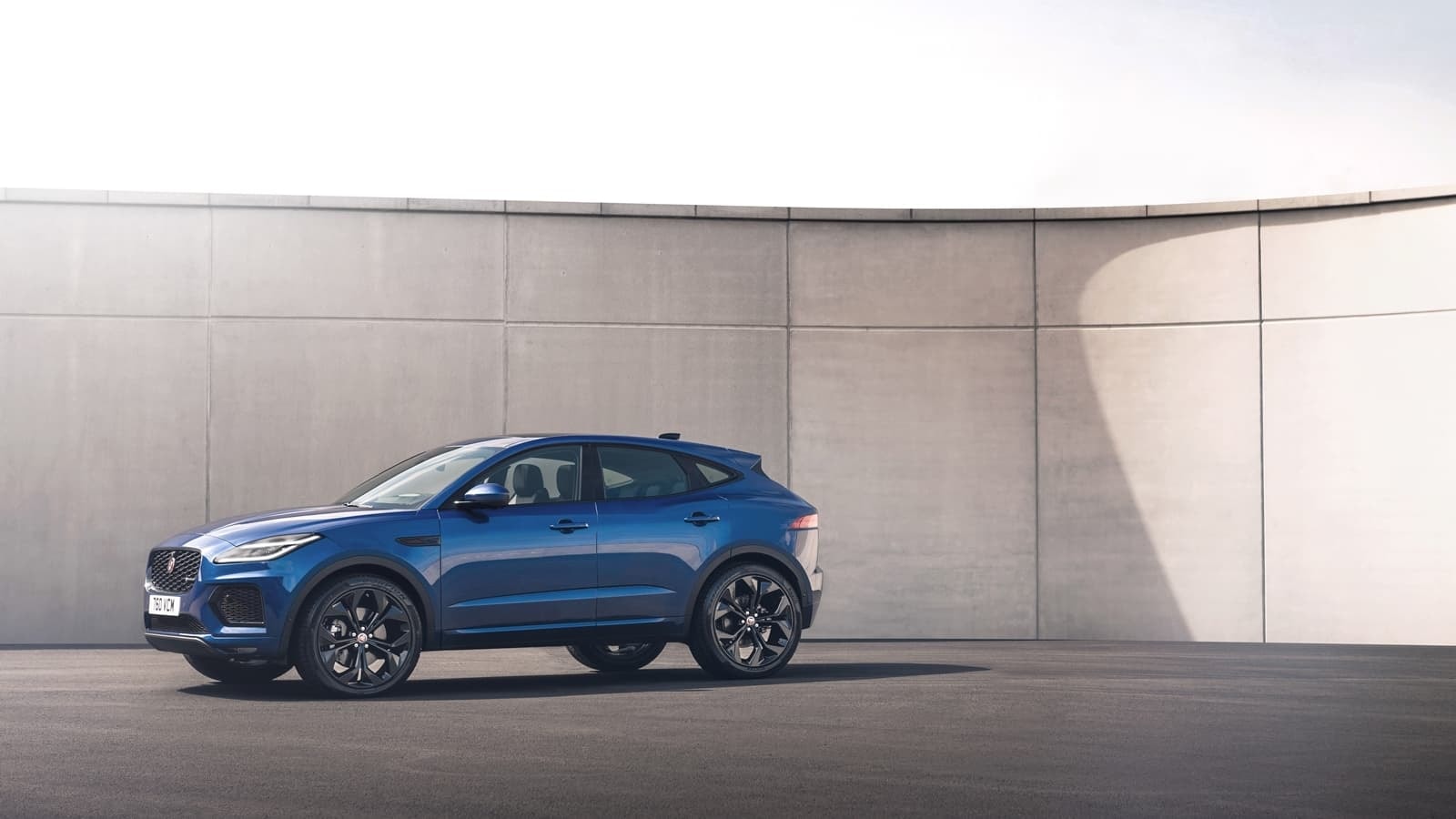 Perfil lateral del Jaguar E-Pace aparcado frente a un muro minimalista