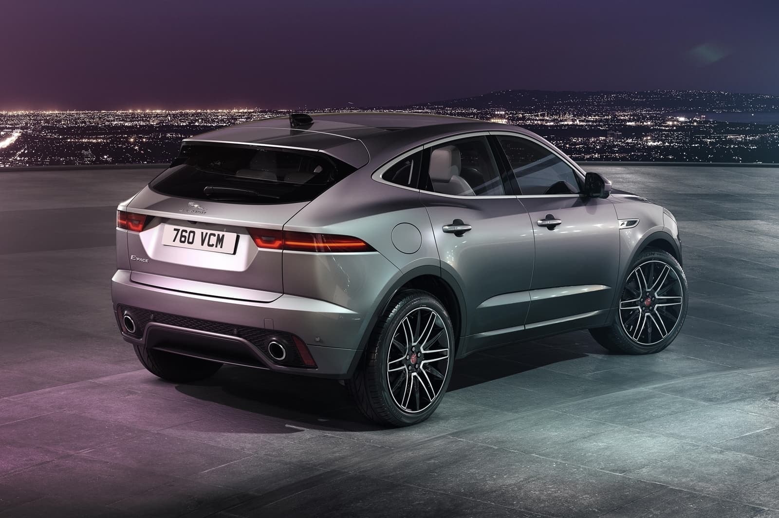 Vista trasera del Jaguar E-Pace bajo iluminación nocturna, resaltando su diseño y luces traseras.