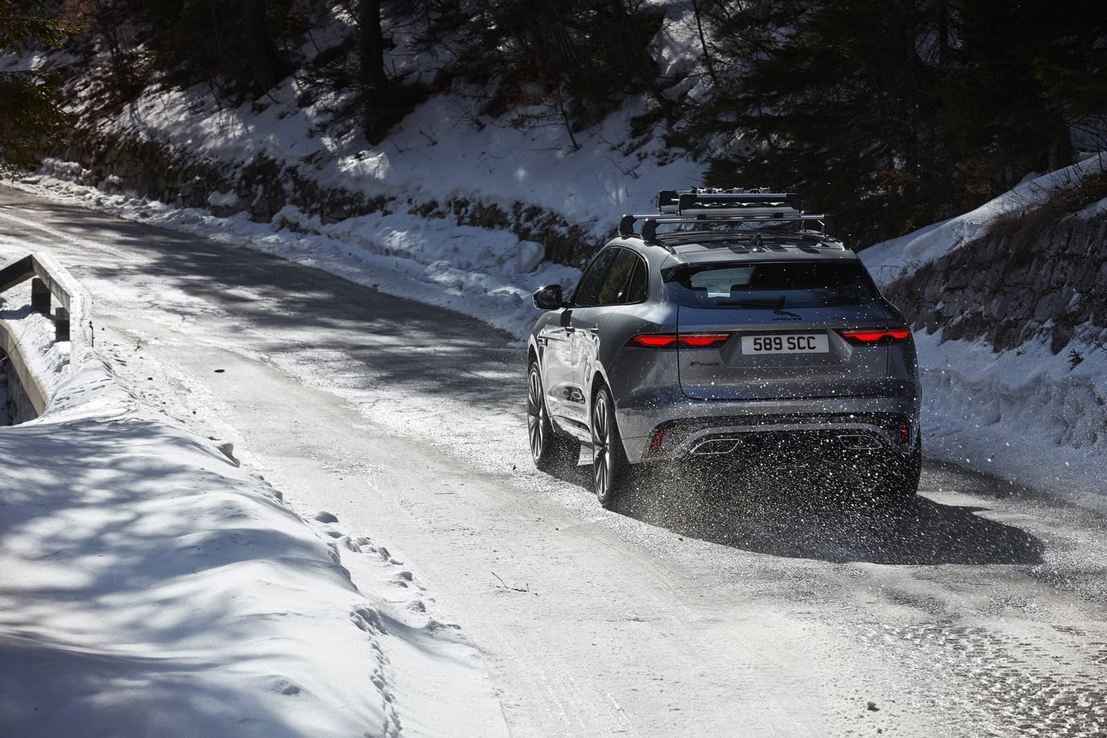 El Jaguar F-Pace en su hábitat invernal, mostrando su zaga y perfil en movimiento.
