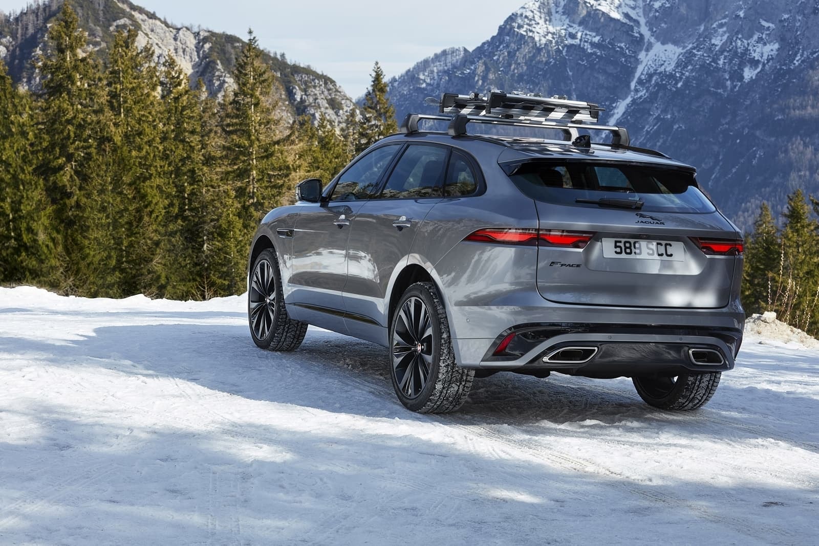 Vista trasera del F-Pace con portaequipajes, listo para la aventura invernal.