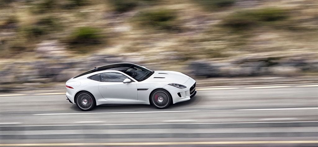 Captura en movimiento del Jaguar F-Type Coupé lateral resaltando su aerodinámica.