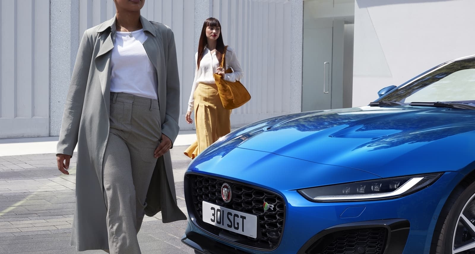 Acercamiento a la zona delantera del Jaguar F-Type azul, enfocando la parrilla y detalles.