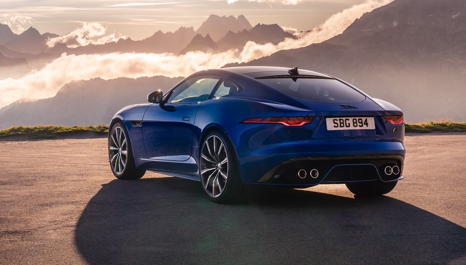 Toma trasera y lateral del Jaguar F-Type al atardecer, destacando el contorno deportivo y elegante.